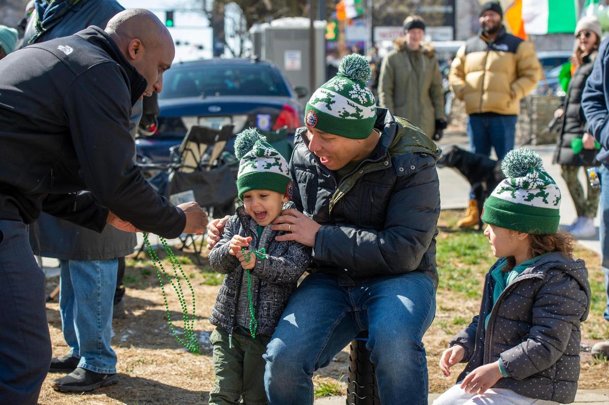Kansas City Mayor Quinton Lucas gives parade attendees green beads during the Kansas City St. Patrick’s Day parade on Friday, March 17, 2023, in Kansas City.