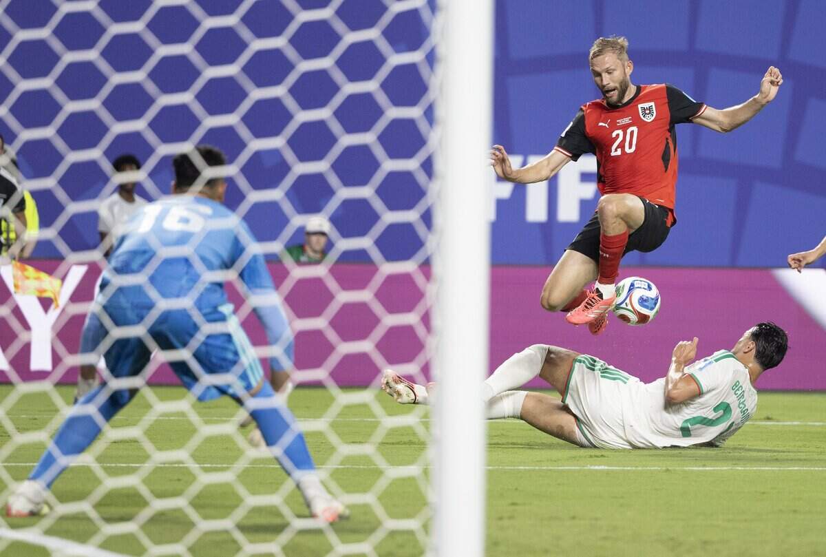 Austria midfielder Konrad Laimer (20) leaps over Algeria defender Ramy Bensebaini (21) during a FIFA World Cup group-stage soccer match at Kansas City (Arrowhead) Stadium in Kansas City on Saturday, June 27, 2026.