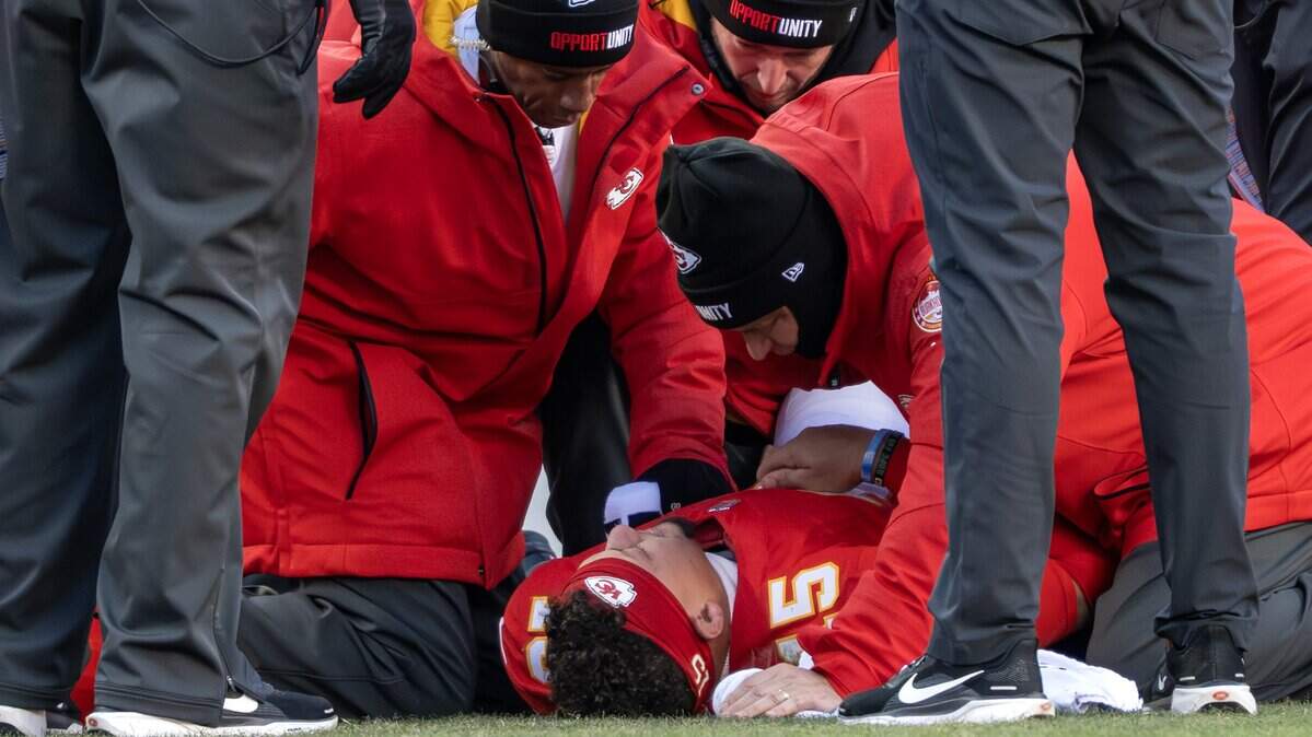 Kansas City Chiefs quarterback Patrick Mahomes (15) is evaluated by team personnel on the sideline after being injured during the fourth quarter of an NFL football game against the Los Angeles Chargers, Sunday, Dec. 14, 2025, at GEHA Field at Arrowhead Stadium.