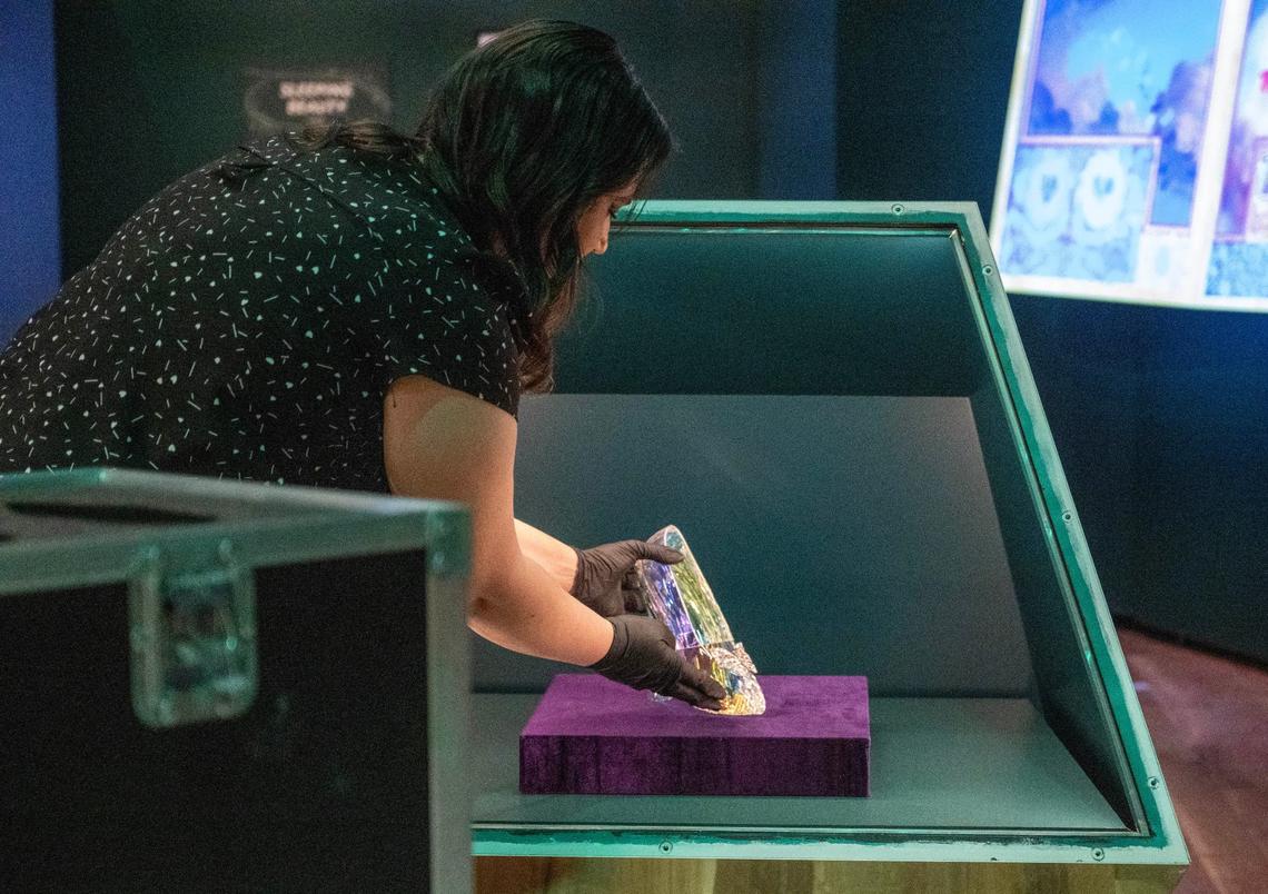 Kelsey Williams, exhibitions creative lead for the Walt Disney Archives, unpacks the slipper from the live action Cinderella (2015) on Monday in preparation for the opening of Disney100: The Exhibition, which opens Friday at Union Station in Kansas City.