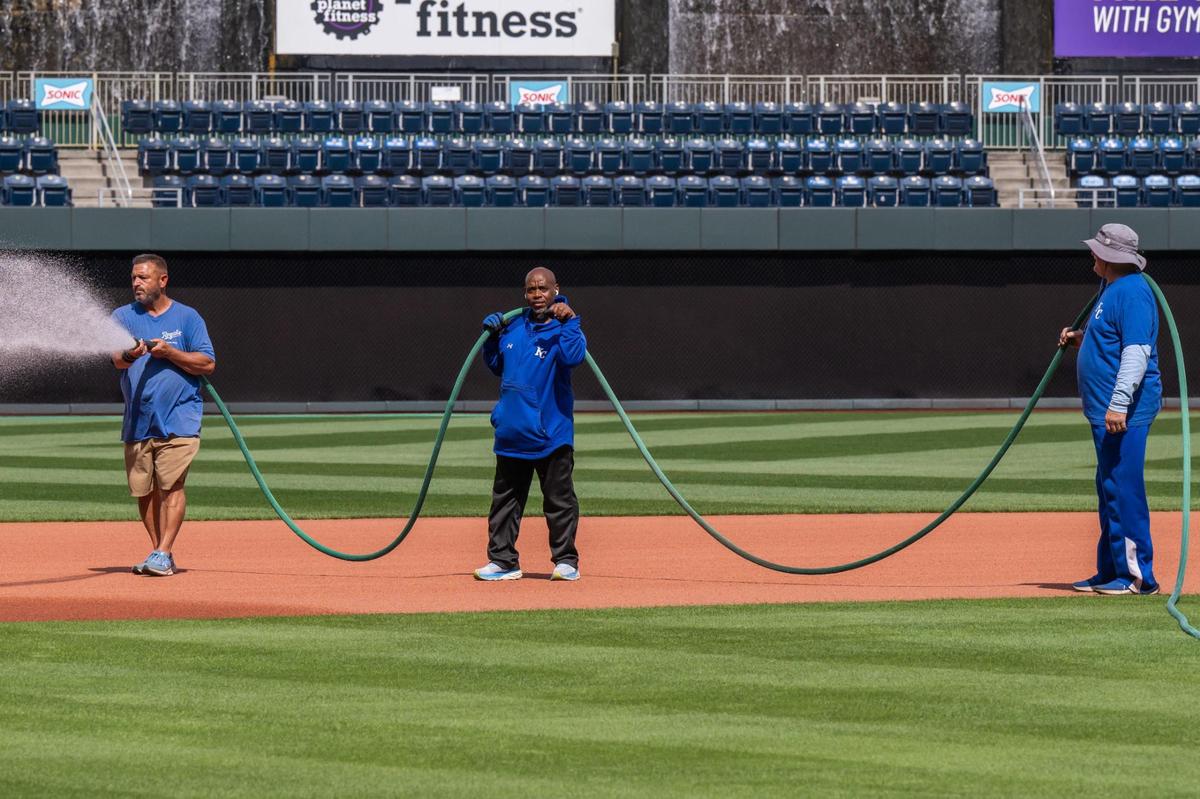 John Reed and a crew of Royals grounds keepers spray water on the infield at Kauffman Stadium on Tuesday, March 25, 2025.