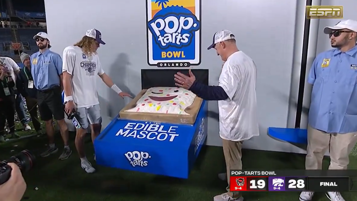 K-State quarterback Avery Johnson and coach Chris Klieman admire the edible Pop-Tarts Bowl mascot before taking a bite.