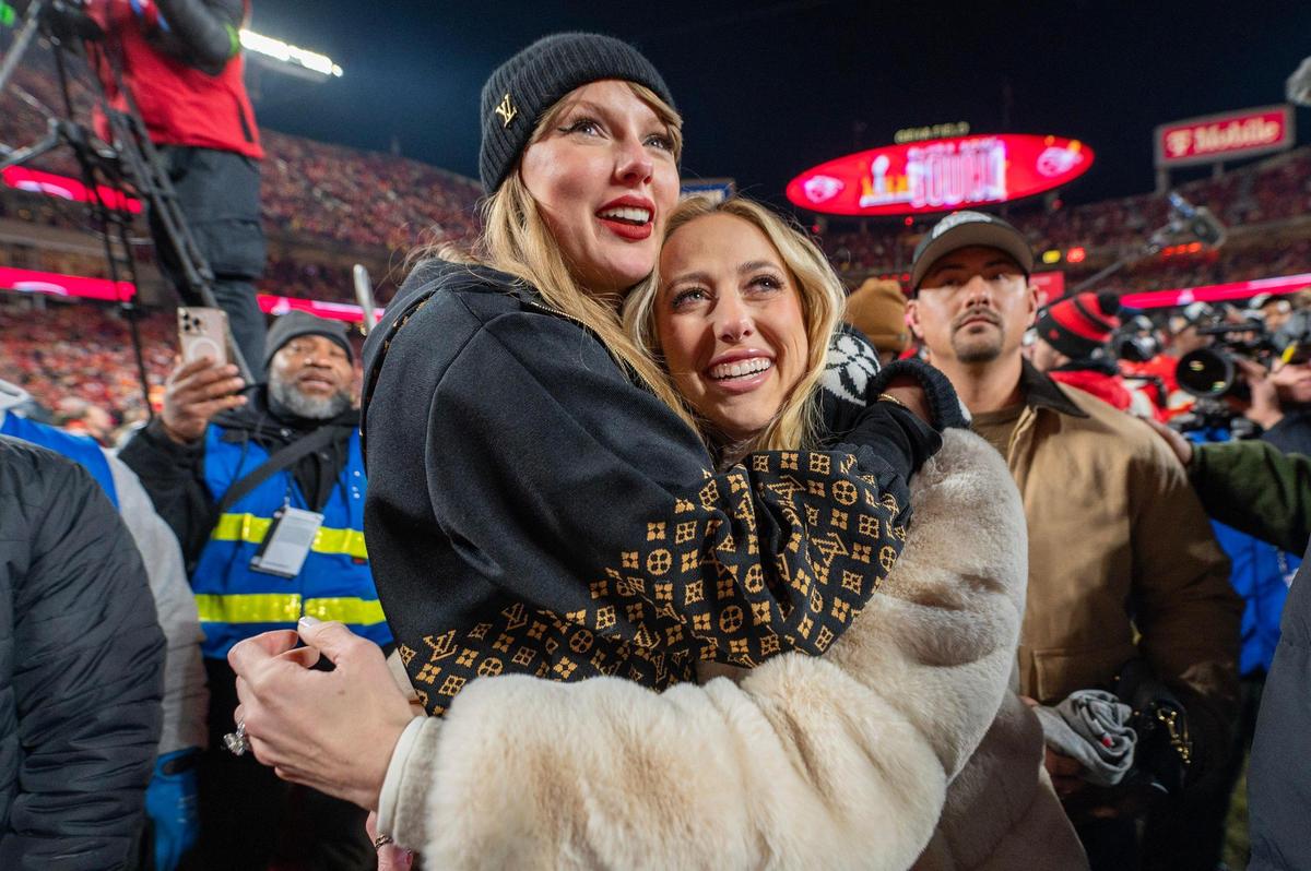 Pop star Taylor Swift, left, embraces Brittany Mahomes, wife of quarterback Patrick Mahomes, as they watch the trophy ceremony following the Chiefs’ 32-29 victory over the Buffalo Bills in the AFC Championship Game on Jan. 26, 2025, at GEHA Field at Arrowhead Stadium.