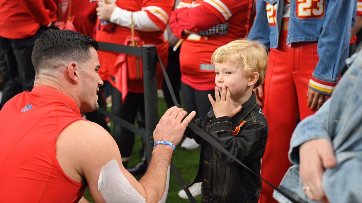 Kansas City Chiefs linebacker Drue Tranquill meets with his son on the sidelines during warm ups before Super Bowl LVIII, Sunday, Feb. 11, 2024, in Las Vegas.