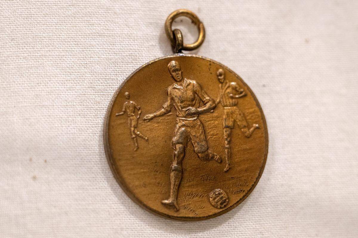 A medallion featuring three people chasing after a ball is displayed in the new exhibition “The Beautiful Game,” highlighting the role of soccer during World War I, at the National WWI Museum and Memorial on Wednesday, April 1, 2026, in Kansas City.