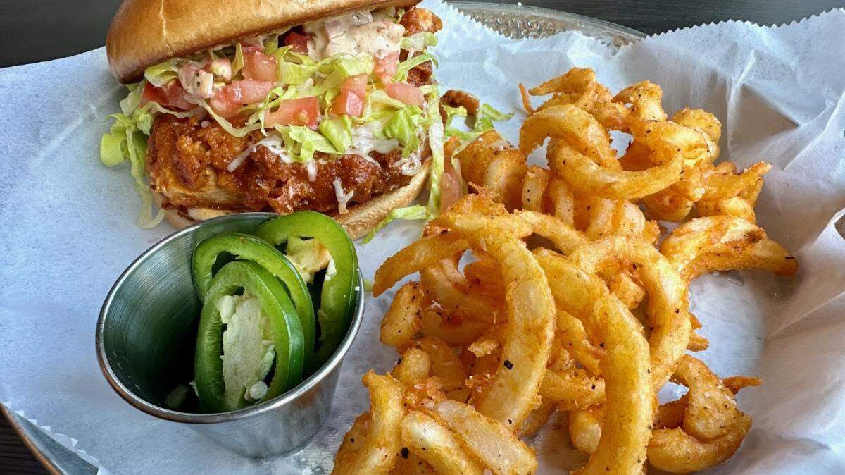 Barrio Taqueria’s Tijuana hot chicken sandwich with chipotle aioli and curly fries.