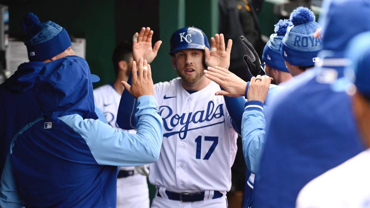 Kansas City Royals infielder Hunter Dozier was congratulated in the dugout after scoring on a 5th inning hit by Nicky Lopez during a 2022 meeting with Cleveland at Kauffman Stadium.