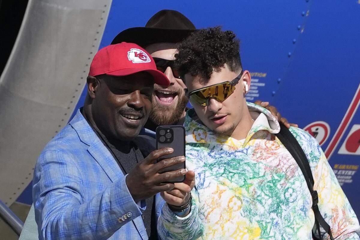 Former Kansas City Chiefs player Christian Okoye poses with Kansas City Chiefs quarterback Patrick Mahomes and tight end Travis Kelce after arriving for Super Bowl 57, Sunday, Feb. 5, 2023, in Phoenix.