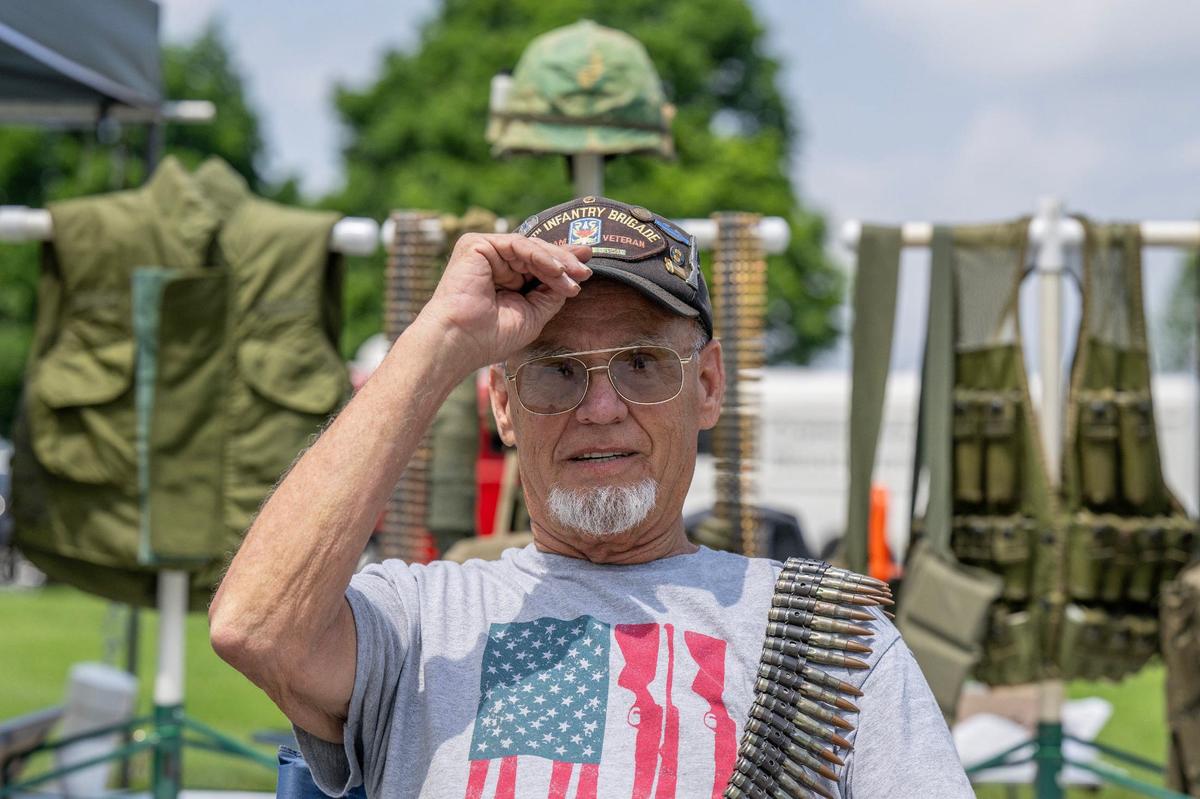 Len Carter, a member of VVA Chapter 243 and an Army veteran, adjusts his hat adorned with a multitude of pins reflecting his time in the military while showcasing his collection of Army gear at the National WWI Museum and Memorial on Friday, May 24, 2024, in Kansas City.