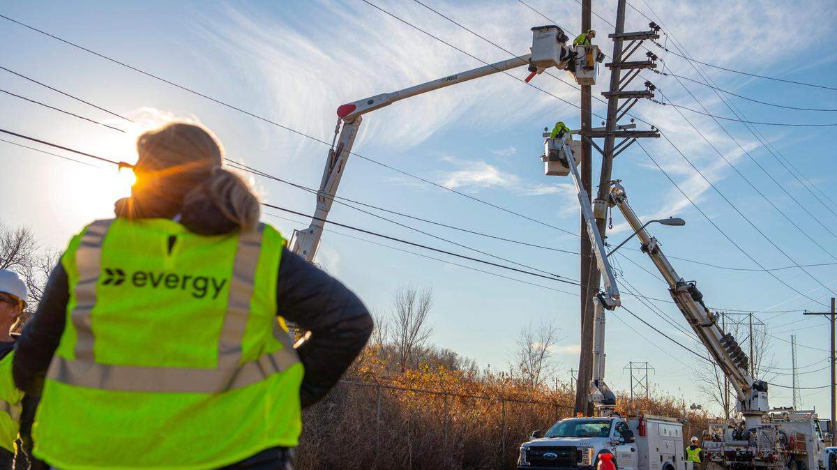 Evergy crew members repair a damaged electricity pole on West 25th Street in Kansas City on Thursday, Dec. 16, 2021. The damage comes a day after Kansas City experienced a severe thunderstorm.