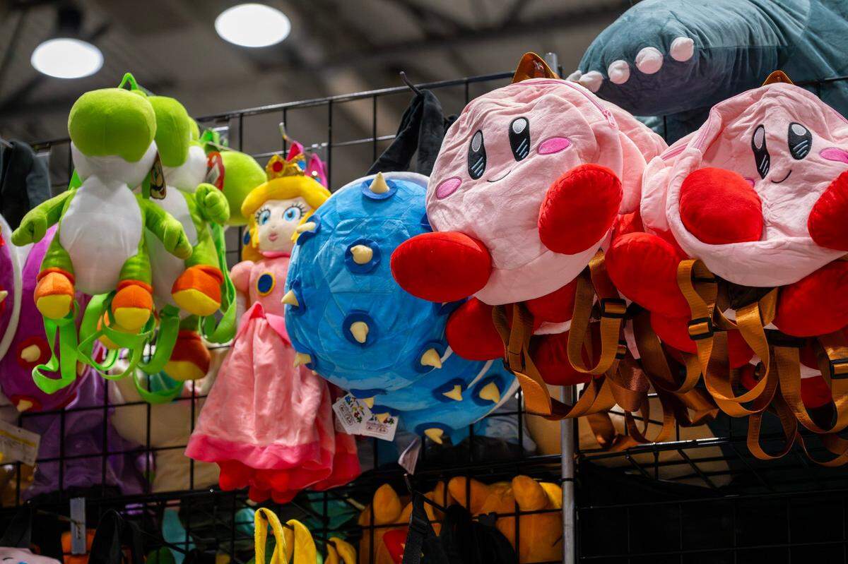 Backpacks featuring characters from Super Mario, Nintendo, and other franchises are displayed along racks at Planet Comicon at the Kansas City Convention Center on Friday, March 21, 2025.
