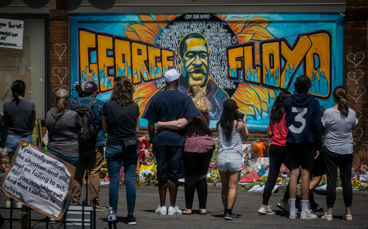 FILE - In this May 31, 2020 file photo, visitors make silent visits to organic memorial featuring a mural of George Floyd, near the spot where he died while in police custody, in Minneapolis, Minn. The message from protesters around the United States is that George Floyd is the latest addition to a grim roster of African Americans to be killed by police. (AP Photo/Bebeto Matthews, File)