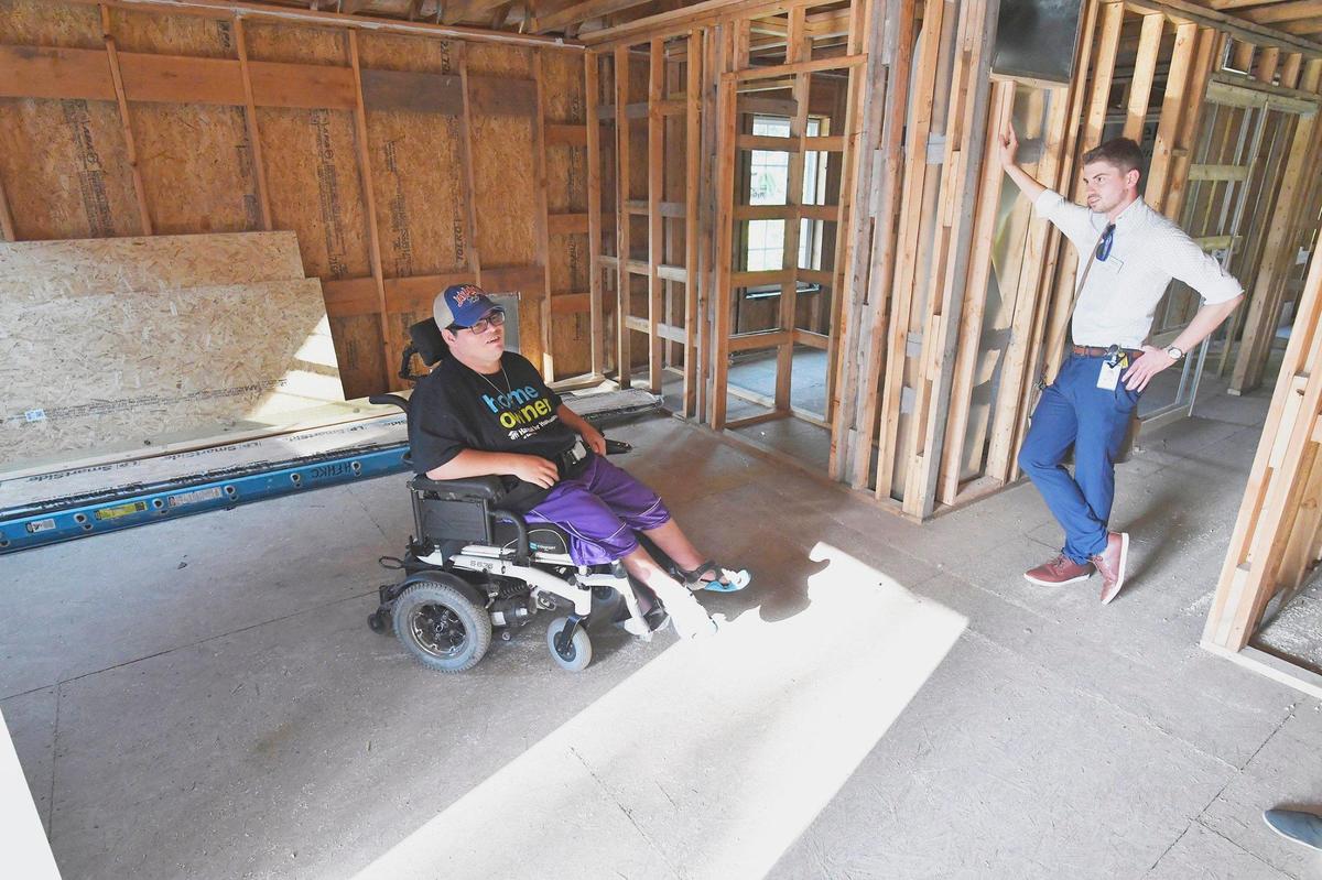 At his new house being constructed on Kansas City’s East Side, Tony Waterhouse-Leal, left, visited recently with Travis Rash of The Whole Person, a nonprofit center for independent living in Kansas City . His new home is being constructed with his specific needs in mind.