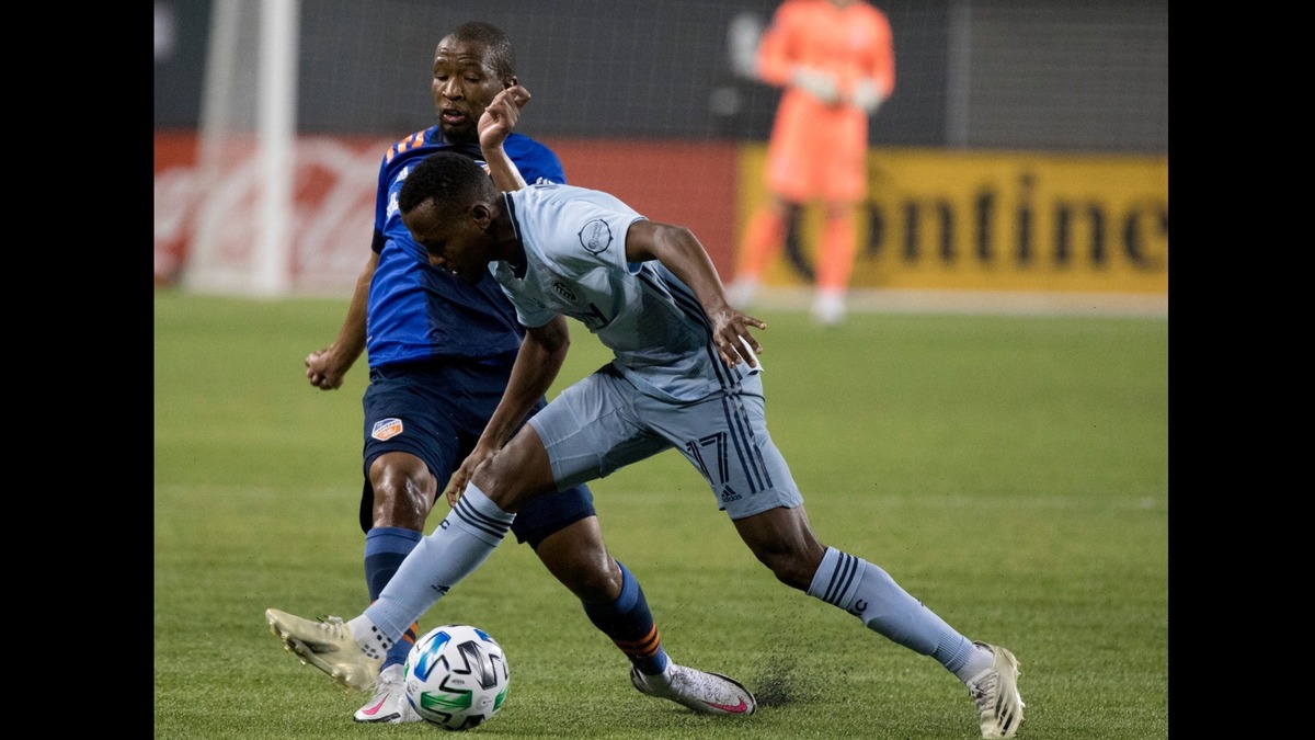 FC Cincinnati midfielder Kamohelo Mokotjo (15) passes the ball past Sporting Kansas City midfielder Gadi Kinda (17) during the first half of an MLS soccer match Wednesday, Oct. 28, 2020, in Cincinnati. (Albert Cesare/The Cincinnati Enquirer via AP)