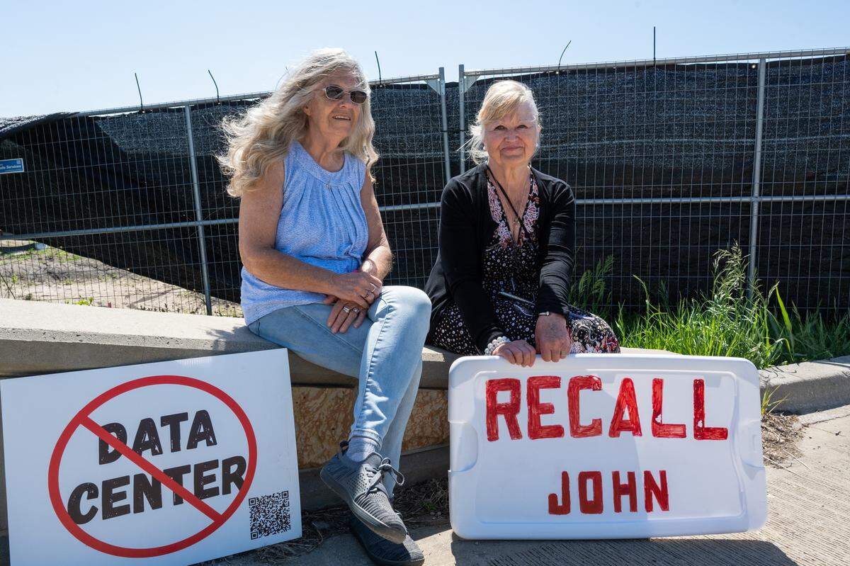 Betty Weaver and Elisa Breitenbach protest near the construction site for Nebius, a future AI data center being built in Independence, on Tuesday, May 12, 2026.