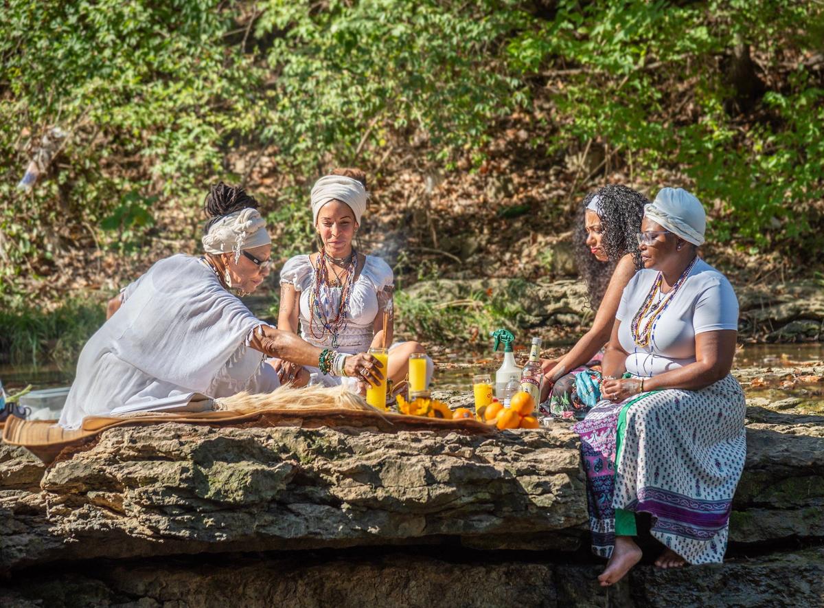 From left: Elder Toni Reynolds, Jicolette Paige Davis, Juliza Marti and Amber Willis participated in a traditional African religious ceremony along the stream in Winterset Park Nature Area in Lee’s Summit.