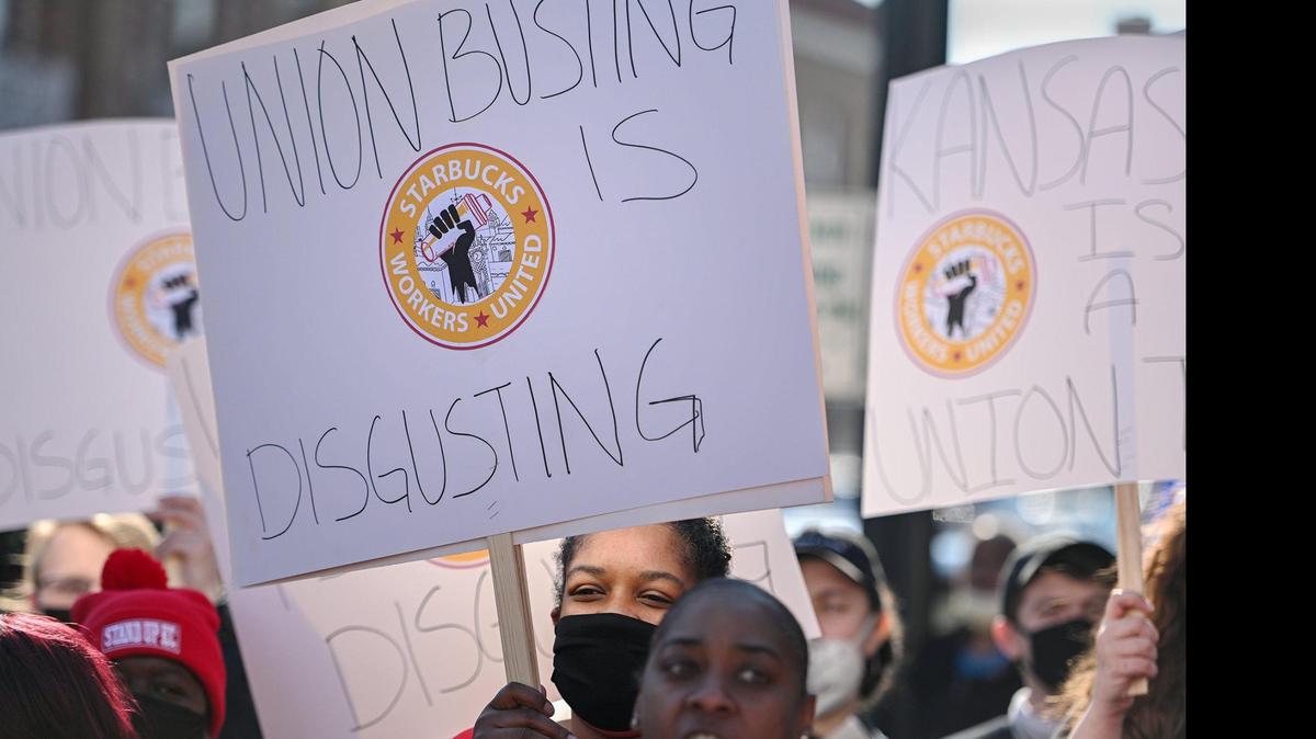 Nakisha Eubanks with Stand Up KC holds a sign in support of Starbucks employees. Eubanks works for Burger King. Dozens of Starbucks employees and union supporters protested alleged anti-union tactics by the company at the Country Club Plaza Starbucks Thursday, March 3, 2022.