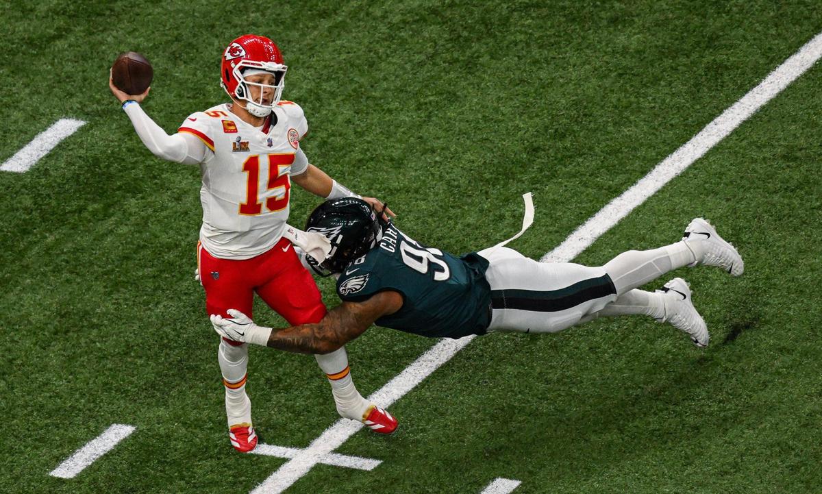 Kansas City Chiefs quarterback Patrick Mahomes (15) throws while in the grasp of Philadelphia Eagles defensive tackle Jalen Carter (98) in the first quarter during Super Bowl LIX on Sunday, Feb. 9, 2025, in New Orleans.