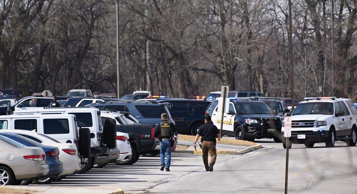 Law enforcement officers, including an FBI agent, were in the parking lot of Olathe North High School Friday morning shortly after a shooting at the school.