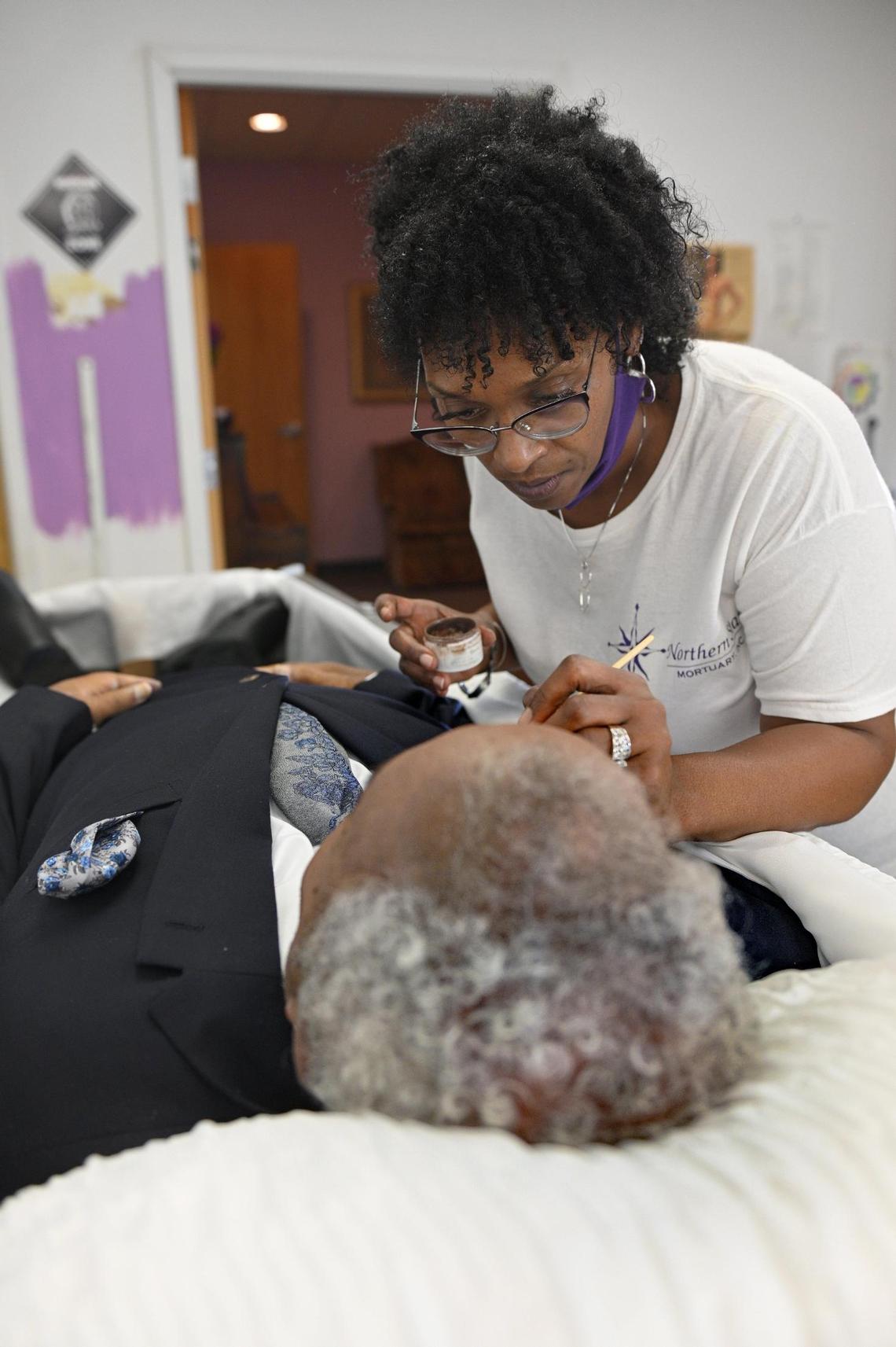 Gwendelrae Hicks, a rare female funeral home owner, touches up the makeup of a deceased man at Northern Star Mortuary in Kansas City, Kansas, which she owns and runs with her husband, Scottie Hicks.