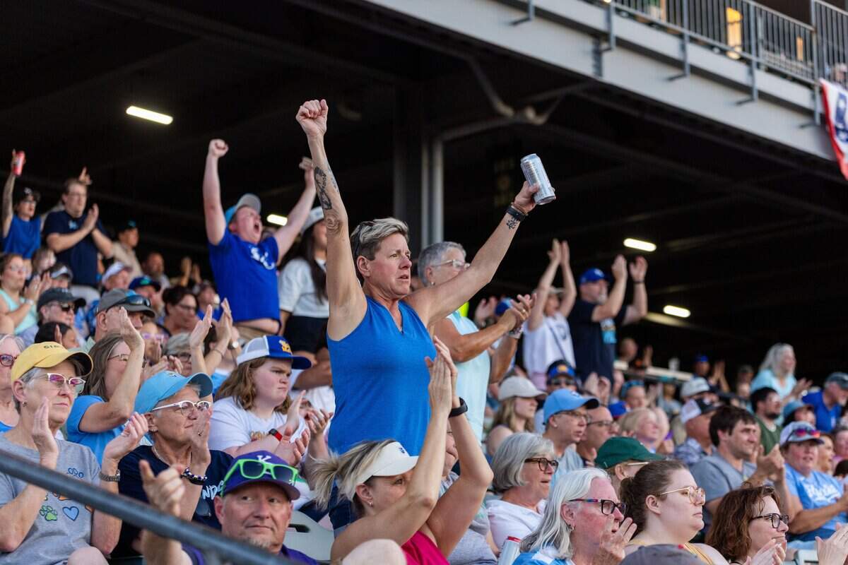 Fans hold their arms out and cheer after an out was called during the KC Diamonds home opener at Legends Field on Wednesday, June 17, 2026.