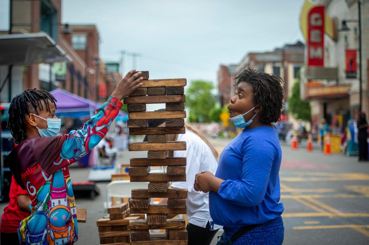 An over-sized game of building blocks grabbed the attention of Madden Tanner, 12, left, and Natis Kincaid, 11, during First Friday festivities in the Historic 18th and Vine District on Friday, May 7, in Kansas City.