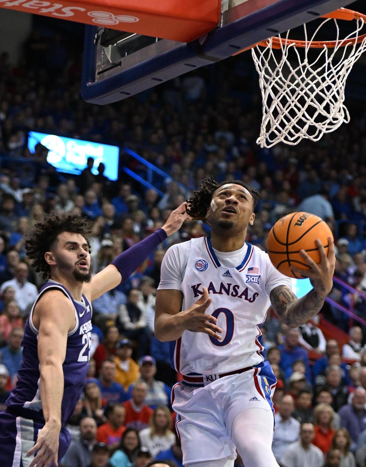 KU’s Bobby Pettiford flew past KSU’s Ismael Massoud for a bucket during the first half of a Sunflower Showdown game at Allen Fieldhouse on Jan. 31, 2023.
