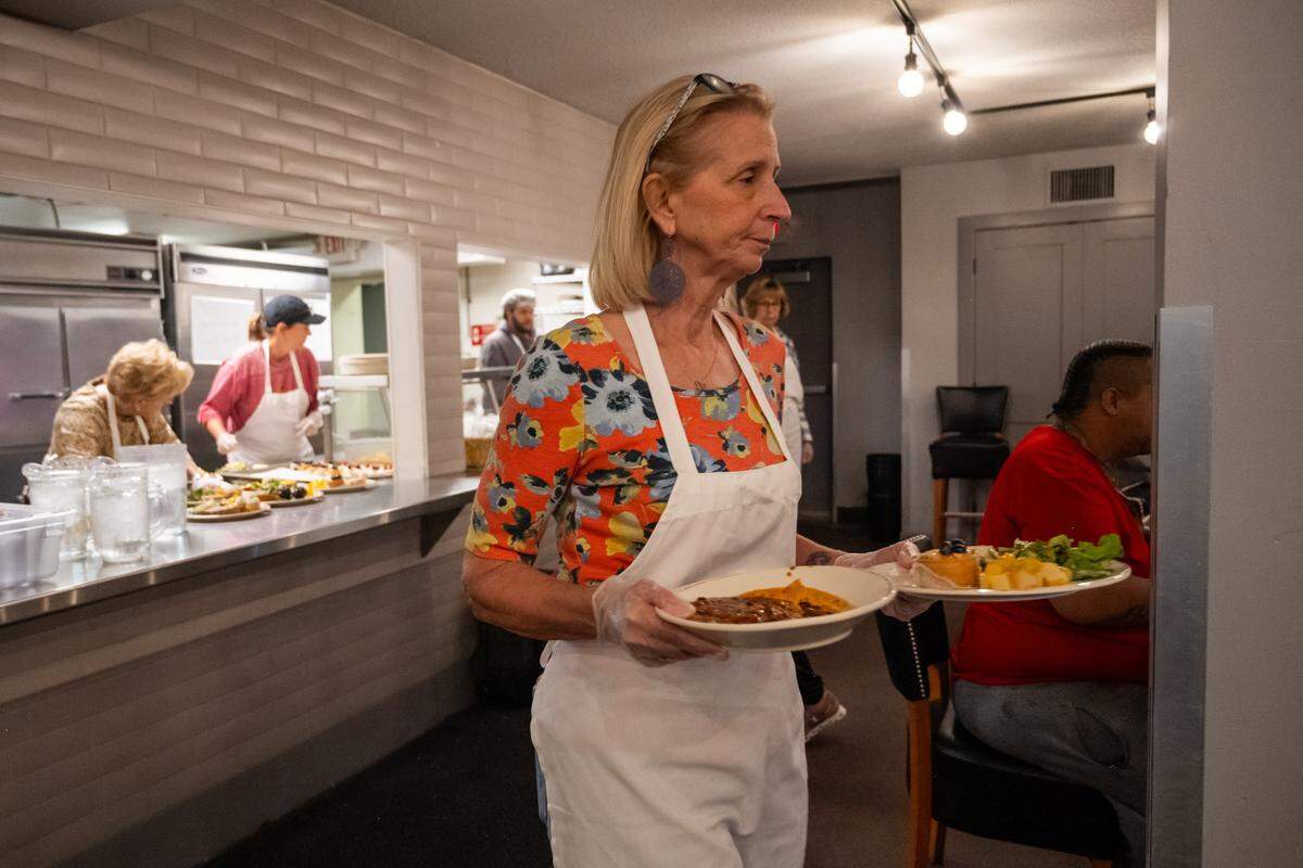 A volunteer serves a hot meal at The Prospect KC, a community kitchen, on Thursday, November 6, 2025, in Kansas City. Homeless customers are able to come and eat a hot meal complete with service and a free pantry.