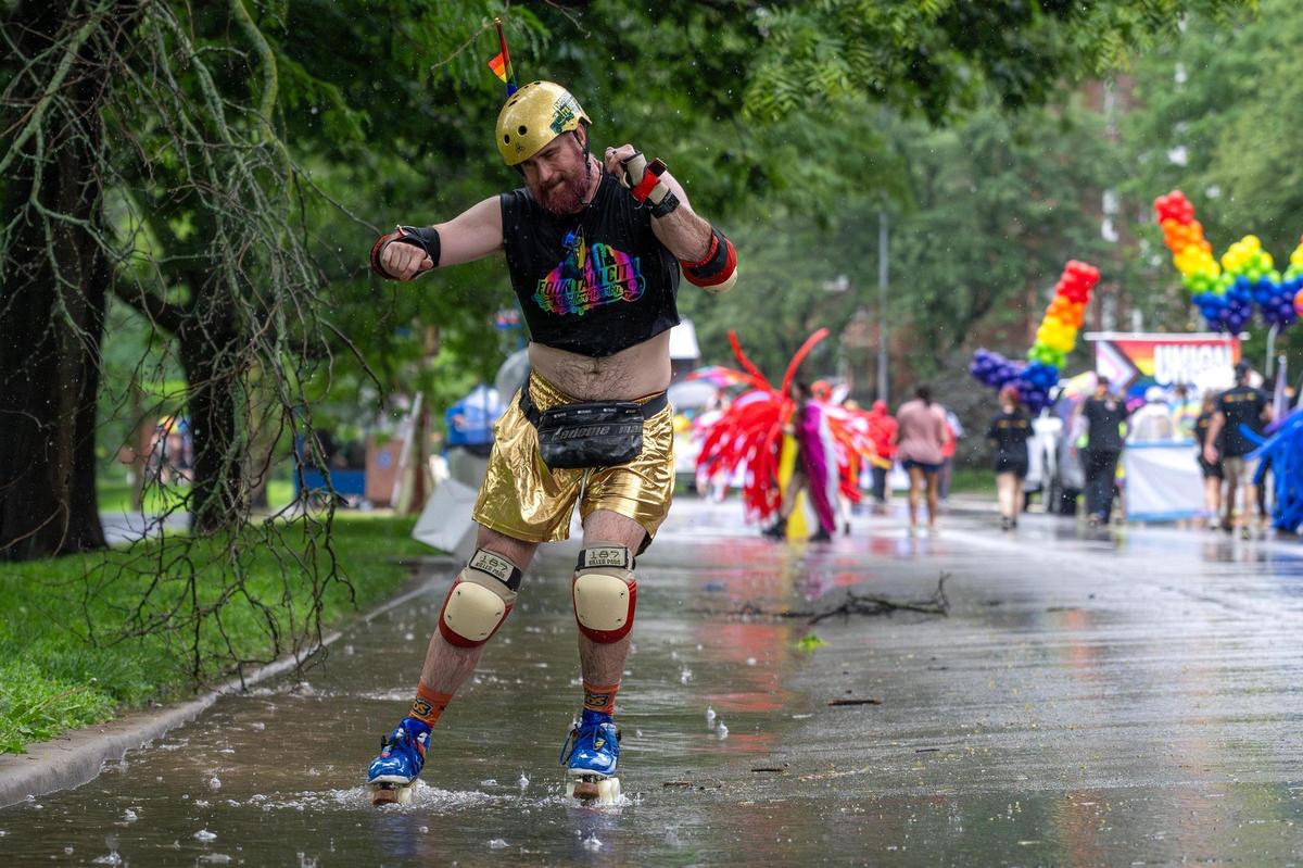 A Fountain City Roller Derby member rollerblades through puddles of water as rain falls during the KC Pride Parade.