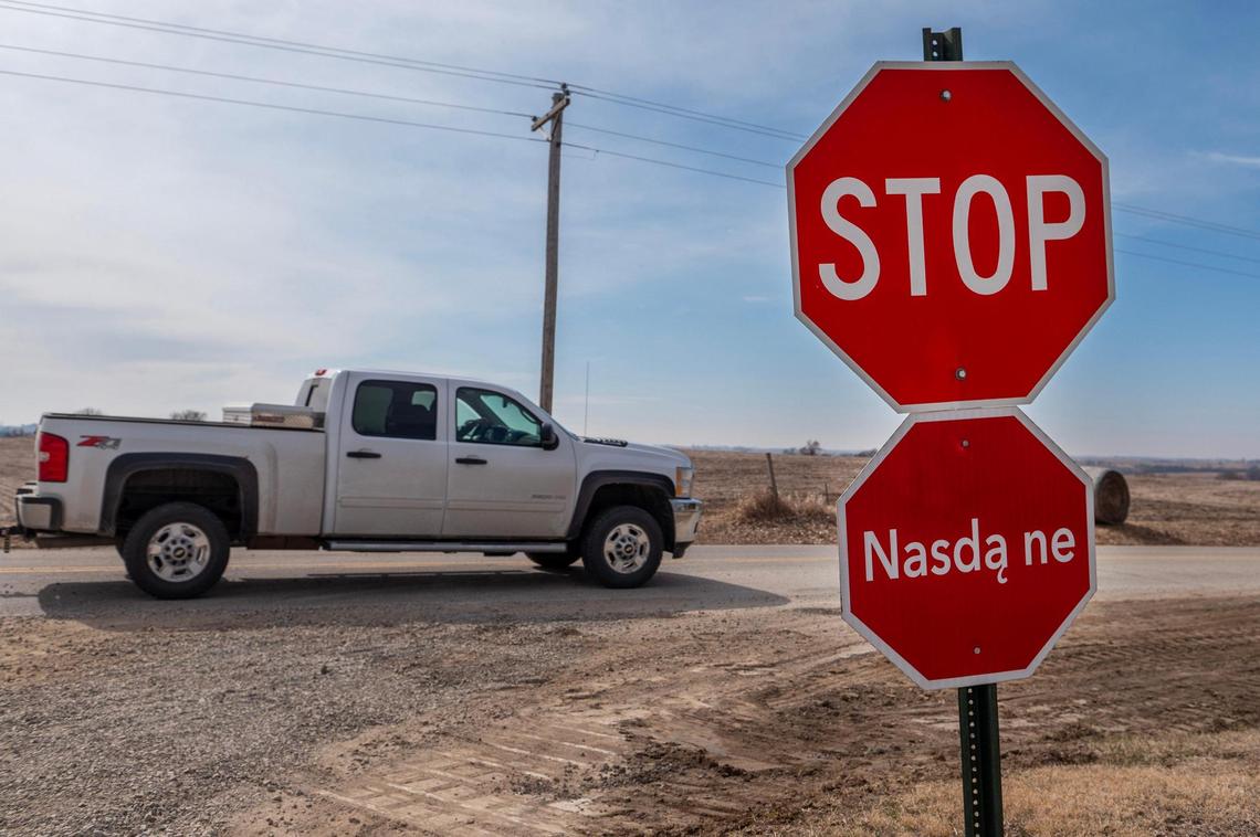 A truck drives by a stop sign translated into the native language of the Iowa Tribe of Kansas and Nebraska at the reservation in White, Cloud, Kansas.