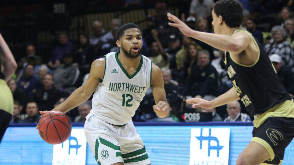 Northwest Missouri State’s Trevor Hudgins drives the ball upcourt under pressure from Emporia State junior Aaron McGee in Thursday’s MIAA Tournament quarterfinals at Municipal Auditorium.