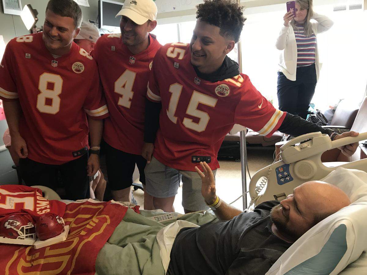 Chiefs players including Patrick Mahomes (No. 15) meet with a hospital patient.