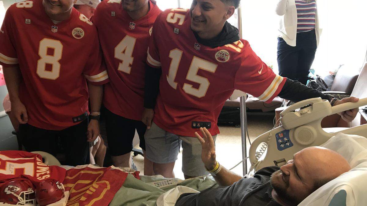 Chiefs players including Patrick Mahomes (No. 15) meet with a hospital patient.