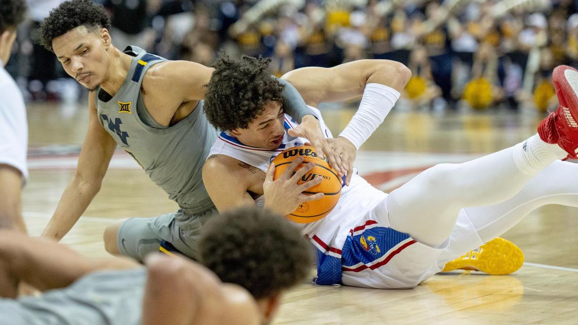 Kansas forward Jalen Wilson, right, fights for possession with West Virginia forward Tre Mitchell during a second-round Big 12 Conference Tournament game on March 9 in Kansas City.
