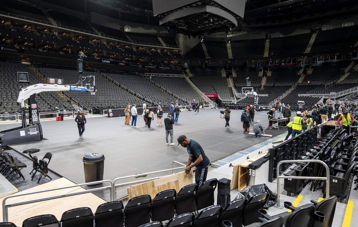 Crews dismantle the Big 12 Men's Basketball Tournament LED basketball court during the midnight hours at T-Mobile Center on Friday, March 13, 2026, in Kansas City.