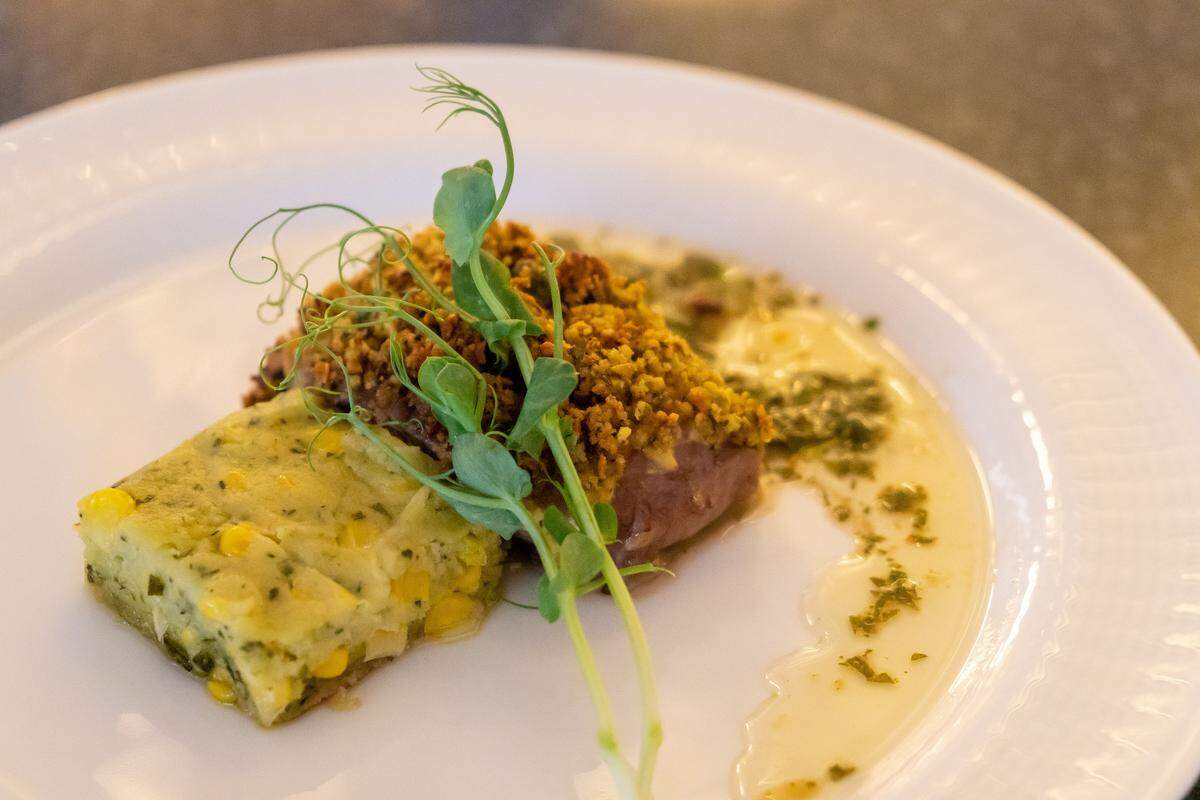 A spring menu find: Pistachio crusted lamb with mint chimichurri and herbed corn pudding at the Dining Experience at Kauffman Center.