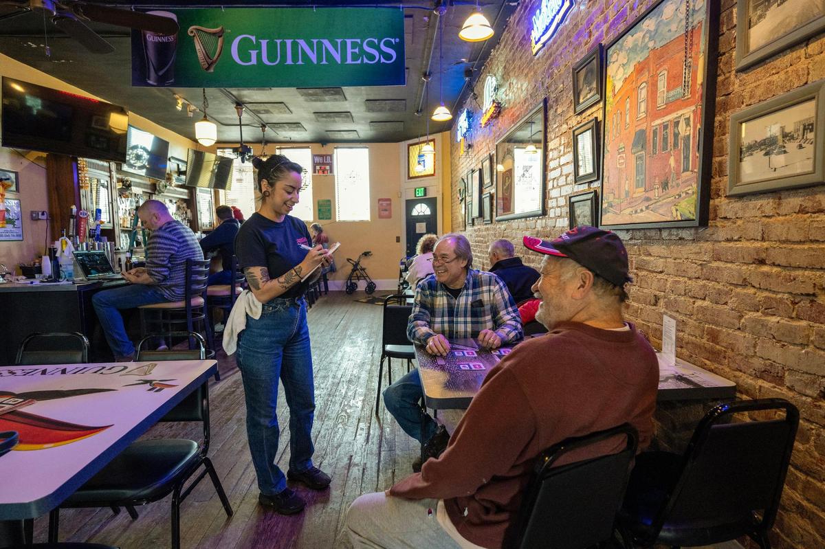 Nancy Patino takes an order from Junior Hernandez, center, of Kansas City, Kansas, and Pete Sanchez of Overland Park at Breit’s Stein & Deli.