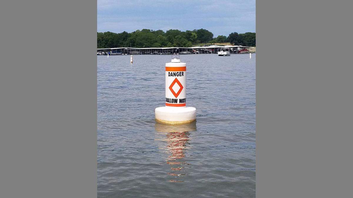 A buoy in Smithville Lake warns boaters of shallow water caused by this spring’s drought.