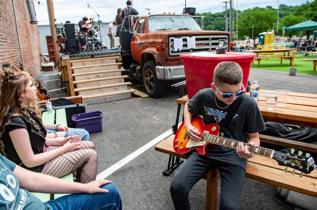 As part of Make Music Kansas City, Sawyer Lane tunes and plays a little bit on a guitar before performing on stage with the rest of the School of Rock Kansas City House Band, Monday, June 21, 2021 at Lemonade Park in Kansas City. The musical event was one of over 70 free performances held as Kansas City made its’ debut on Make Music Day, a world-wide celebration of music happening in over 1,000 cities in 120 countries.