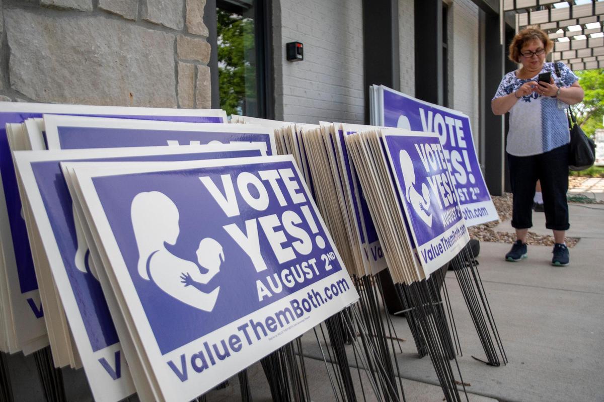 Yard signs were available at the Value Them Both Tailgate and Rosary Rally June 5 in Overland Park. The signs urge voters to approve an amendment removing the right to abortion from the state constitution.