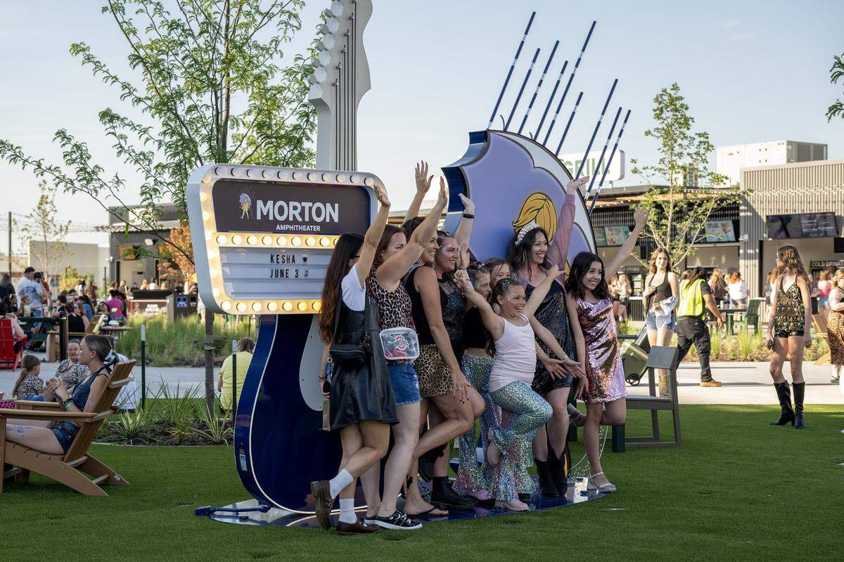 People pose for a photo beside a guitar-shaped display at the Morton Amphitheater on Wednesday, June 3, 2026, in Riverside.