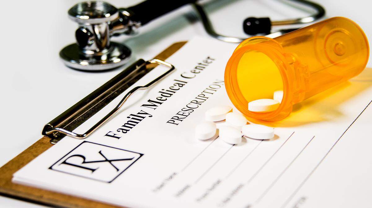 File photo of a medical prescription pad and pills.