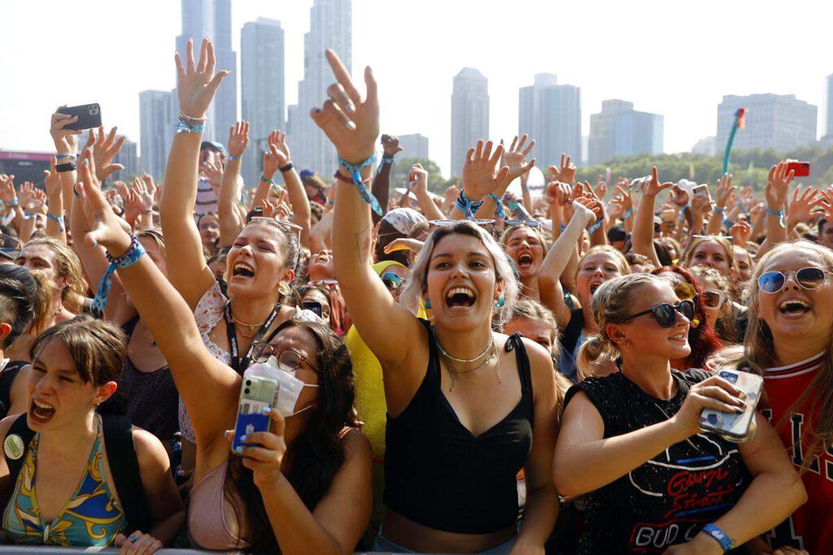 Fans cheer and wave their hands in the air on day one of the Lollapalooza music festival on Thursday, July 29, 2021, at Grant Park in Chicago. Despite concerns from some that the festival would turn into a COVID-19 super-spreader, officials said Aug. 12 it was not.