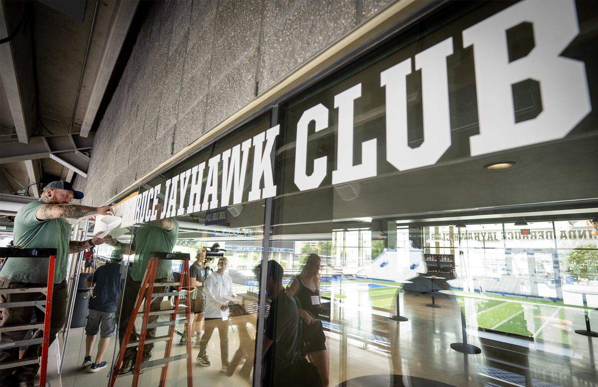 Drew Halling of Fullbright Sign of Lawrence adds lettering to a sign in progress at the new David Booth Kansas Memorial Stadium on Tuesday, Aug. 19, 2025, at the University of Kansas in Lawrence.  