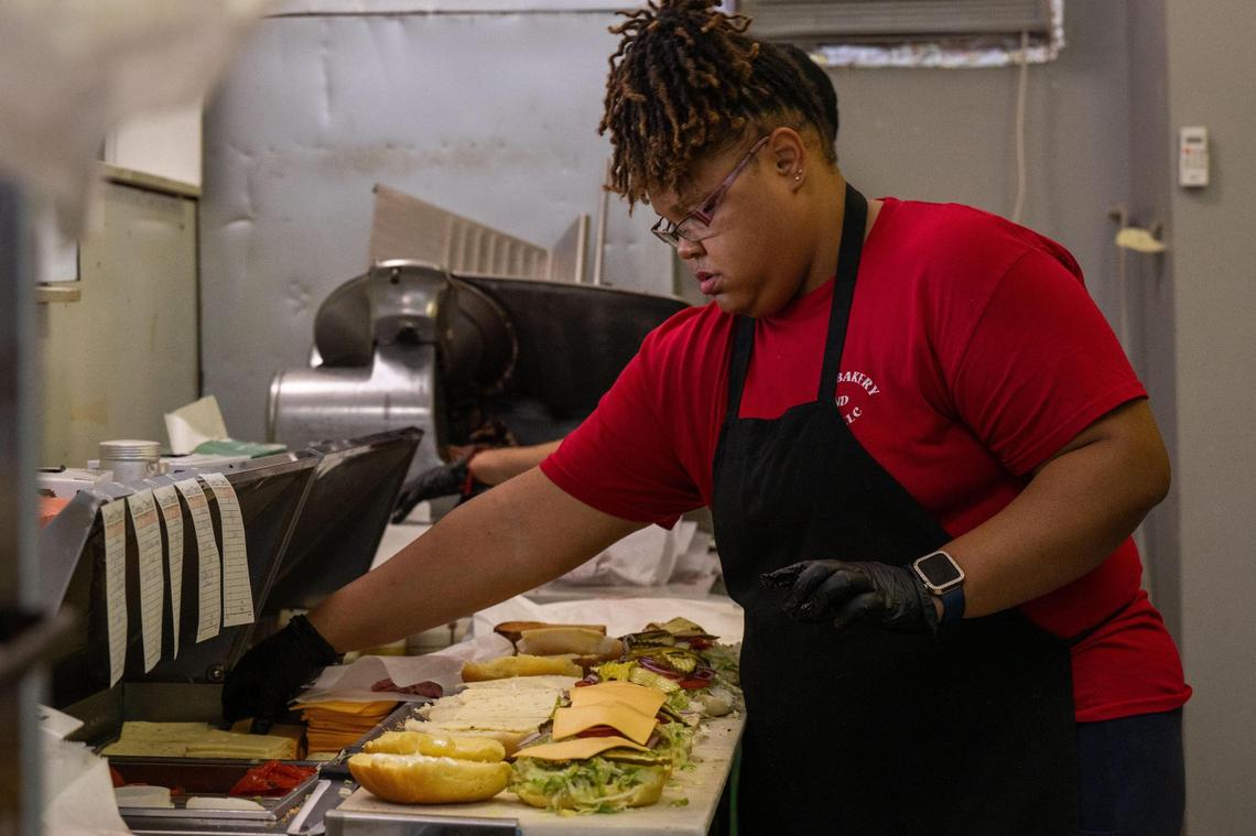 Latrice Williams prepares a line of Hook ‘Em Up sandwiches at M & M Bakery and Delicatessen.