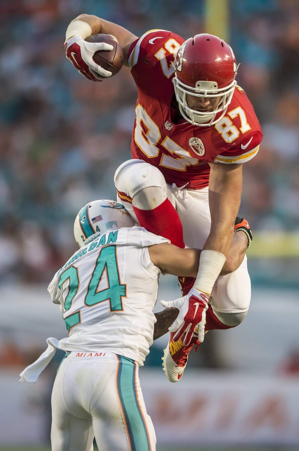 Kansas City Chiefs tight end Travis Kelce tries to leap over Miami Dolphins cornerback Cortland Finnegan for a 7-yard gain at Sun Life Stadium in Miami Gardens, Florida, on September 21, 2014. The Chiefs won 34-15. It was the first game for Kelce to score in since joining the Chiefs.