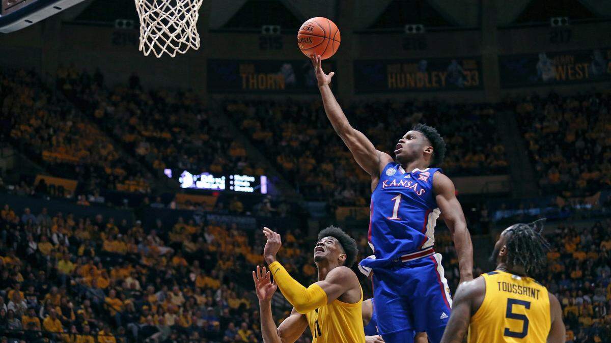 Kansas guard Joseph Yesufu zeroes in on a floater as he’s defended by West Virginia forward Mohamed Wague (No. 11) and guard Joe Toussaint (5) during Saturday’s game in Morgantown, W.Va.