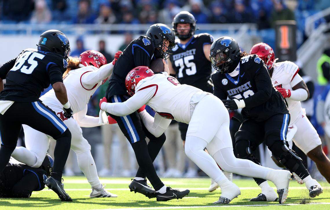 Brock Vandagriff #12 of the Kentucky Wildcats is sacked by Rene Konga #90 of the Louisville Cardinals at Kroger Field on November 30, 2024 in Lexington, Kentucky.