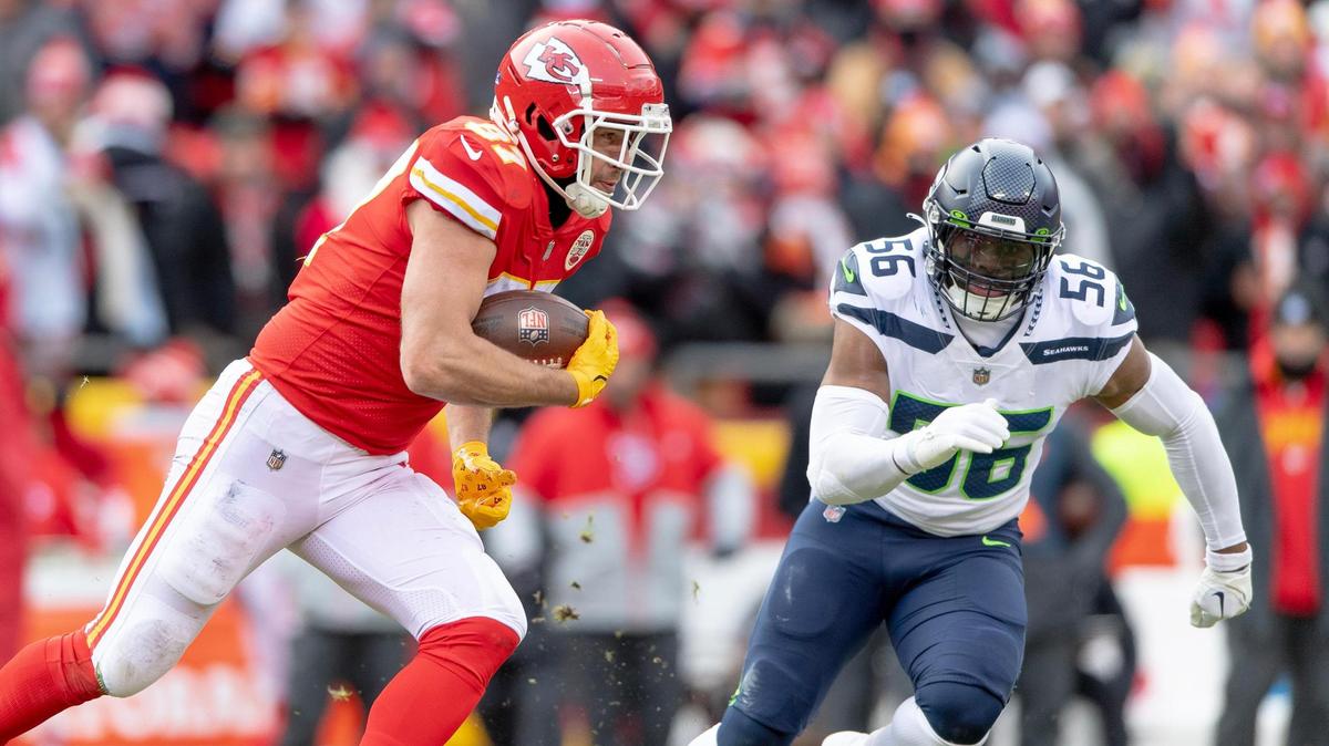 Kansas City Chiefs tight end Travis Kelce (87) runs the ball as Seattle Seahawks linebacker Jordyn Brooks (56) gives chase during the second half of an NFL football game at Arrowhead Stadium on Saturday, Dec. 24, 2022, in Kansas City.