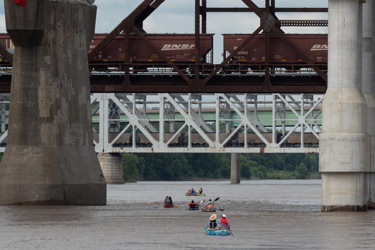 Boats particpating in the Kawsmouth River Carnival boat parade are dwarfed by bridges they passed under Saturday on the Missouri River.